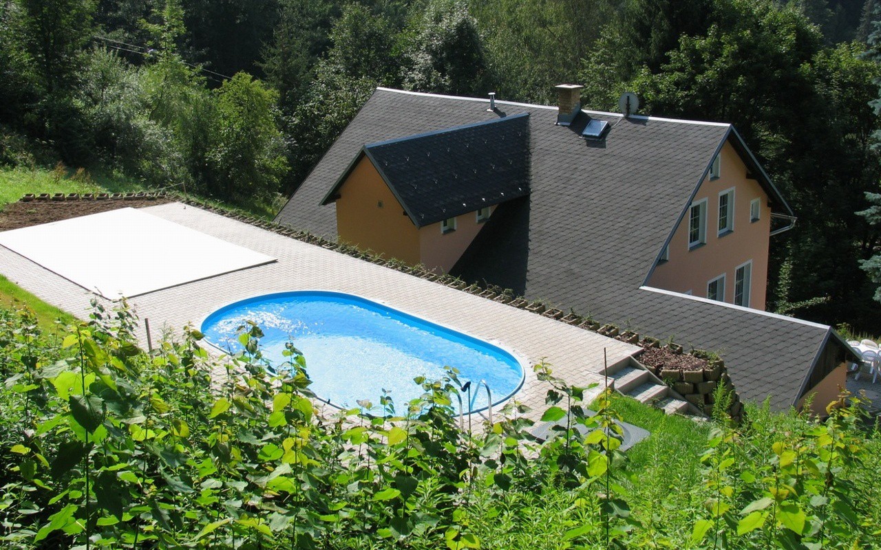 Sunbathing at the heated pool above the tops of Jizera mountains ...